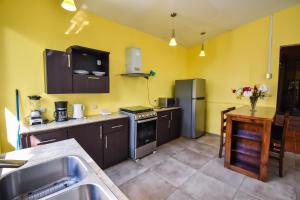 a kitchen with a sink and a stove top oven at Hotel Tabú & Spa in Puerto Viejo