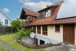 ein Haus mit Sonnenkollektoren auf dem Dach in der Unterkunft Ferienwohnung CasaNova in Finning