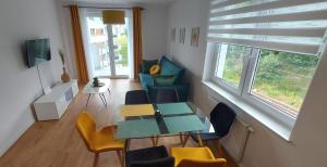 d'un salon avec une table, des chaises et une fenêtre. dans l'établissement Allewidok 2, à Jelenia Góra