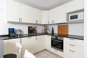 eine weiße Küche mit weißen Schränken und Geräten in der Unterkunft Ferienwohnung CasaNova in Finning