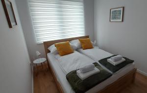a bed with two pillows on it in a room with a window at Allewidok 2 in Jelenia Góra