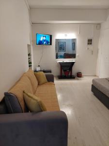 a living room with a couch and a flat screen tv at PlazaVerrosA6Room in Tripoli