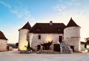 un viejo castillo con dos torres encima. en Hôtel Les Vieilles Tours Rocamadour en Rocamadour
