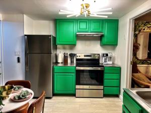 uma cozinha verde com um frigorífico e uma mesa em Secret Garden Denver em Denver