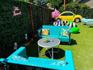 um quintal com bancos azuis e uma mesa e um carro em Secret Garden Denver em Denver