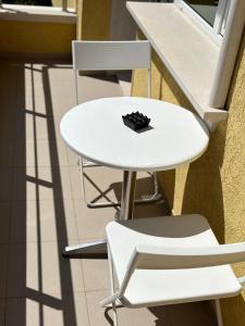 Una mesa blanca y dos sillas al lado de una mesa blanca y sillas en Hedi Sozopol, en Sozopol