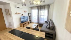 a living room with a couch and a tv at Apartamento golf-resort murcia in Murcia
