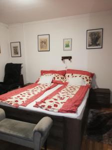 a bed in a bedroom with a red and white blanket at Árnyas Vendégház in Hajdúszoboszló