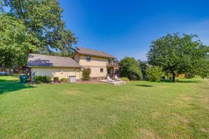 a home with a large yard with a house at Spacious Arkansas Abode with Balcony and Fire Pit! in Fort Smith