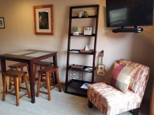 a living room with a table and a couch and a television at Lake Chelan View Condo in Downtown near Beach! in Chelan