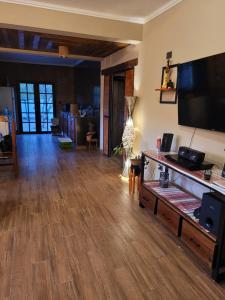 salon z drewnianą podłogą i telewizorem z płaskim ekranem w obiekcie CASA de PURMAMARCA w mieście Purmamarca