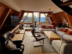 a living room with a couch and a tv at le chalet pointu de capucine in Bourg-Saint-Maurice