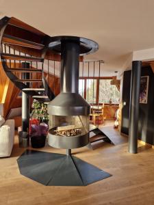 a fireplace in the middle of a living room at le chalet pointu de capucine in Bourg-Saint-Maurice