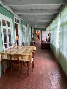 a dining room with a wooden table and green walls at Sakhli Rachashi სახლი რაჭაში in Ambrolauri