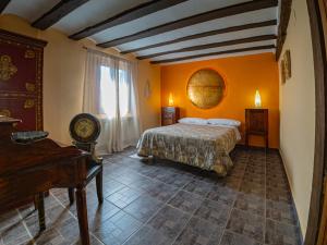 Un dormitorio con una cama y un piano en una habitación en La Aldea Encantada, en Quintanilla del Monte