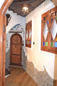 pasillo con puerta y ventanas de madera en Dar Touijar, en Chefchaouen