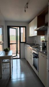 uma cozinha com uma mesa, um lavatório e um fogão em Bonito apartamento en Marbella con piscina em Marbella