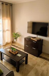 uma sala de estar com uma mesa de centro e uma televisão de ecrã plano em Bonito apartamento en Marbella con piscina em Marbella
