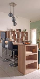 a kitchen with a counter with chairs and a bowl of fruit at L'Appart Aixois - au coeur de la ville - Location in Aix-les-Bains
