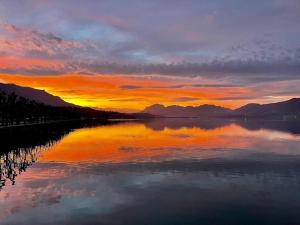 a sunset over a body of water with mountains at L'Appart Aixois - au coeur de la ville - Location in Aix-les-Bains +4 photos