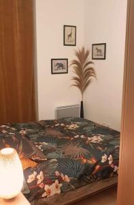 a bedroom with a bed with a blanket with flowers at L'Appart Aixois - au coeur de la ville - Location in Aix-les-Bains