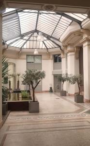 a building with a glass ceiling with potted trees in it at L'Appart Aixois - au coeur de la ville - Location in Aix-les-Bains