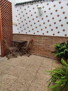 un patio con un banco y una pared de ladrillo en Balcón de la Villa, en Priego de Córdoba