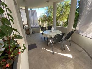 a patio with a table and chairs on a porch at Apartment Tree Of Life in Kaštela
