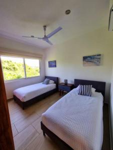 a bedroom with two beds and a window at Depto en Diamante con Club de Playa Privado in Acapulco