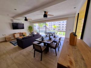 a living room with a table and chairs and a couch at Depto en Diamante con Club de Playa Privado in Acapulco