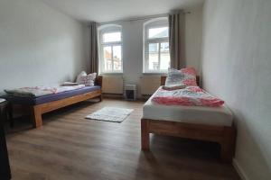 Zimmer mit 2 Betten und 2 Fenstern in der Unterkunft Monteurswohnung Roßwein - Zentral - Küche in Roßwein