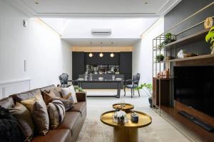 ein Wohnzimmer mit Sofa und Tisch in der Unterkunft Georgetown Luxury Heritage House 4BR 10Pax in George Town