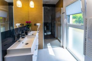 La salle de bains est pourvue de 2 lavabos et d'une douche. dans l'établissement Klif Resort Apartamenty, à Mechelinki