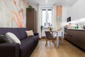 a living room with a blue couch and a kitchen at Exotic House in central of Milan in Milan