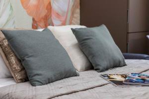 a bed with two pillows and a magazine on it at Exotic House in central of Milan in Milan