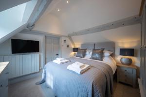 a bedroom with a bed with towels on it at Vine Cottage in Halford