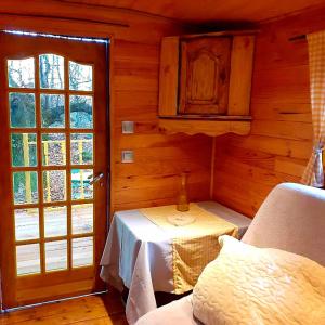 Zimmer mit einem Tisch und einem Fenster in einer Hütte in der Unterkunft Roulotte avec piscine la jonquille in Valgorge