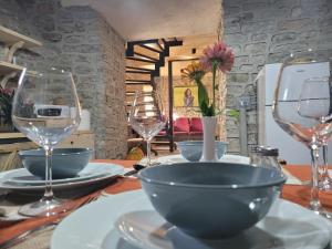 a table with plates and wine glasses on it at Melodia - Harmony Heaven in Gjirokastër