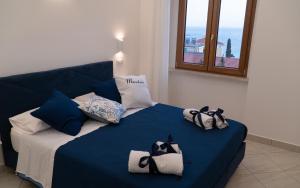 un letto blu con sopra asciugamani di Mareterè a Vietri