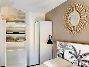 1 dormitorio con espejo y 1 cama en charmant 2 pièces, neuf et cosy, en Jonzac