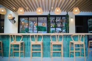 a bar with four stools sitting at a counter at Odysseia Hotel Kapetanios in Limassol