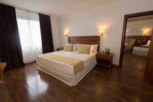 a hotel room with a large bed and a mirror at Hotel Saint George in Puerto Iguazú