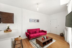 a living room with a red couch and a table at Luxury London Canary Wharf 2 bed apt in London