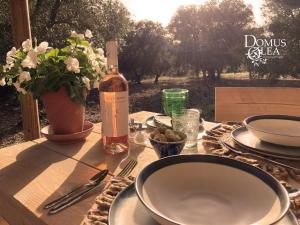 a table with a bottle of wine and a bowl on it at Domus Olea Glamping in Ceglie Messapica