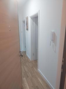 a hallway with a white door and a wooden floor at Milica in Trebinje