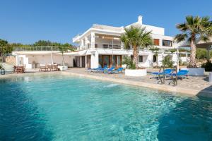 a swimming pool in front of a house at Arte Suites Pefki in Pefki Rhodes