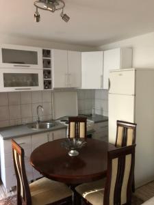 una cucina con tavolo, sedie e frigorifero di Apartman Pionirska a Sarajevo