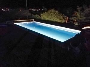 a swimming pool at night with the lights on at cabañas santa catalina in Villa Giardino