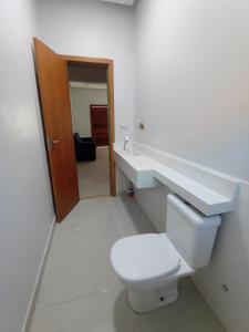 a bathroom with a toilet and a sink at Residência em Bairro Nobre in Imperatriz