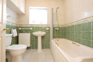 a bathroom with a toilet and a sink and a bath tub at Badgers End in Chipping Campden